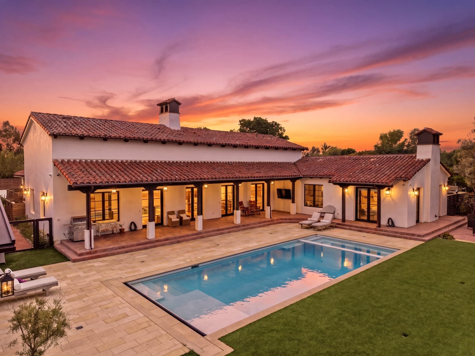 Spanish-style estate at twilight, every light on, seen from above
