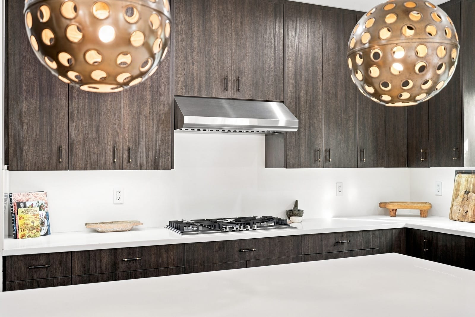 Kitchen with gold globe pendants over a white island