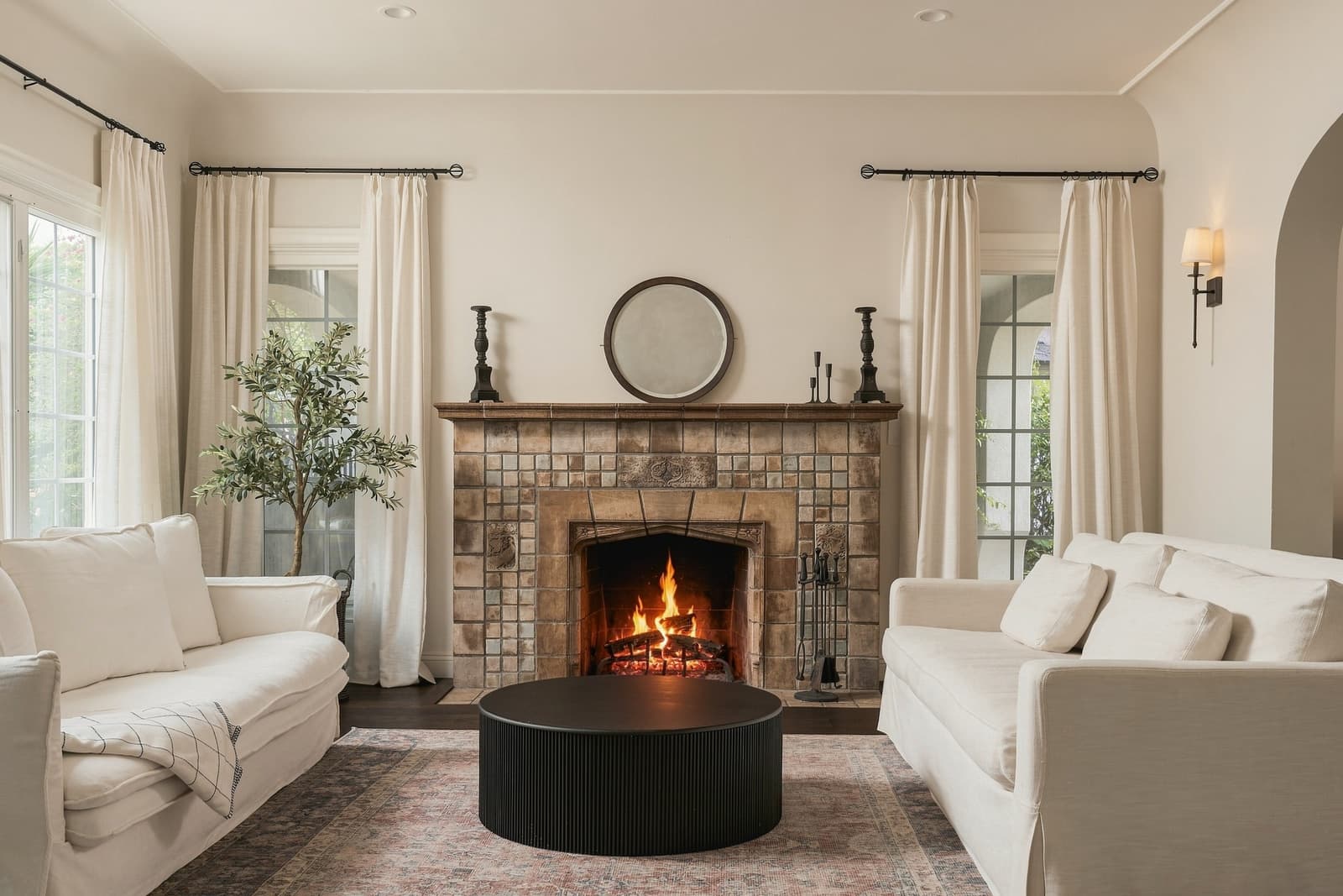 Living room with the tiled fireplace lit, seen straight on