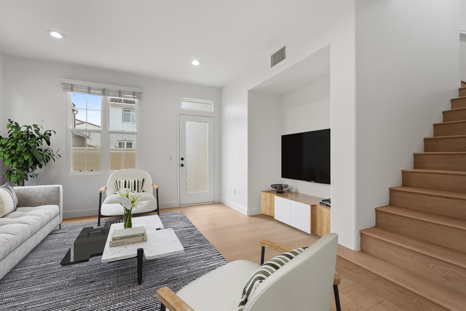 The same living room, virtually staged with a sectional and a media console