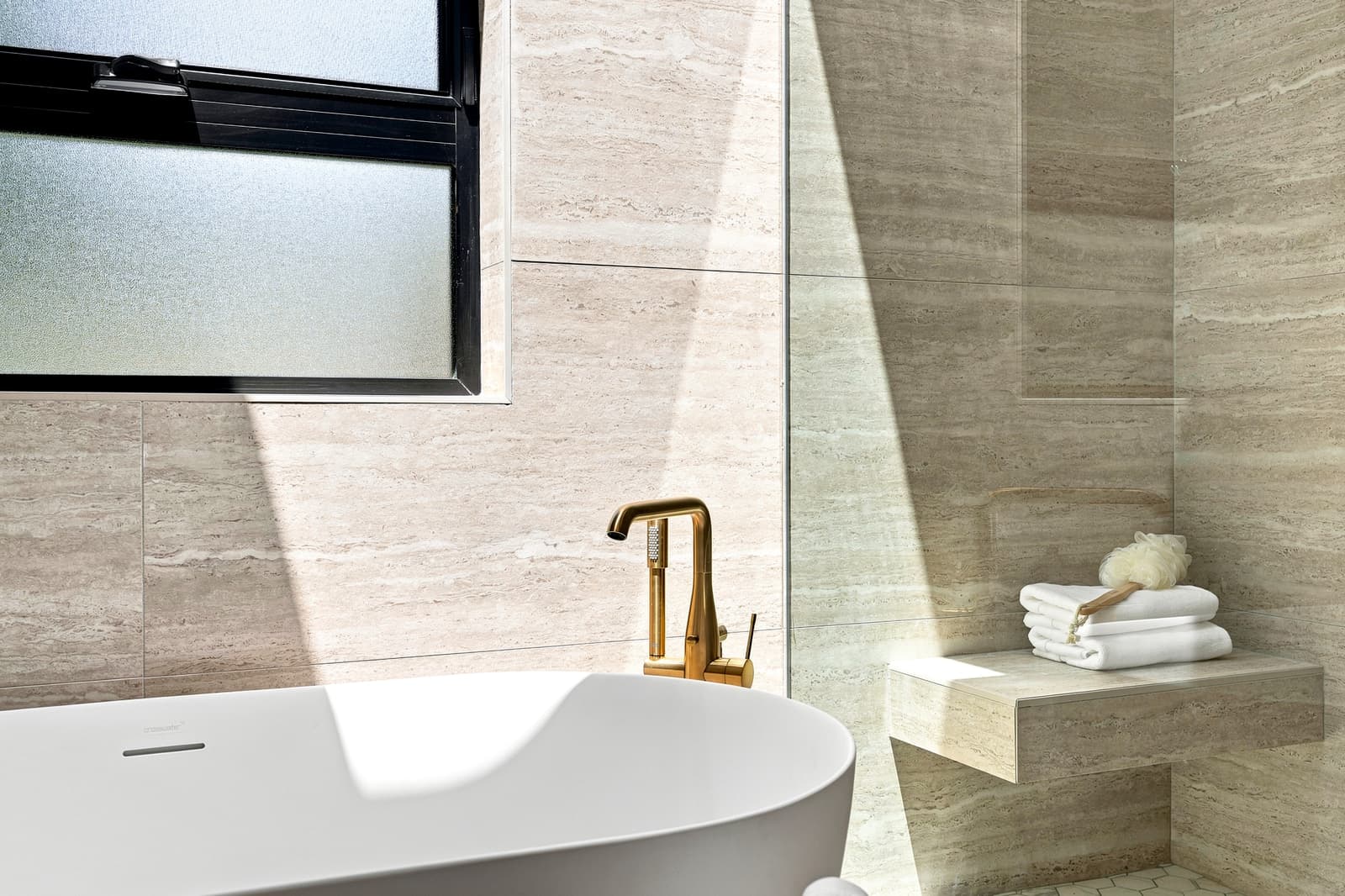 Stone bathroom with a soaking tub in soft light