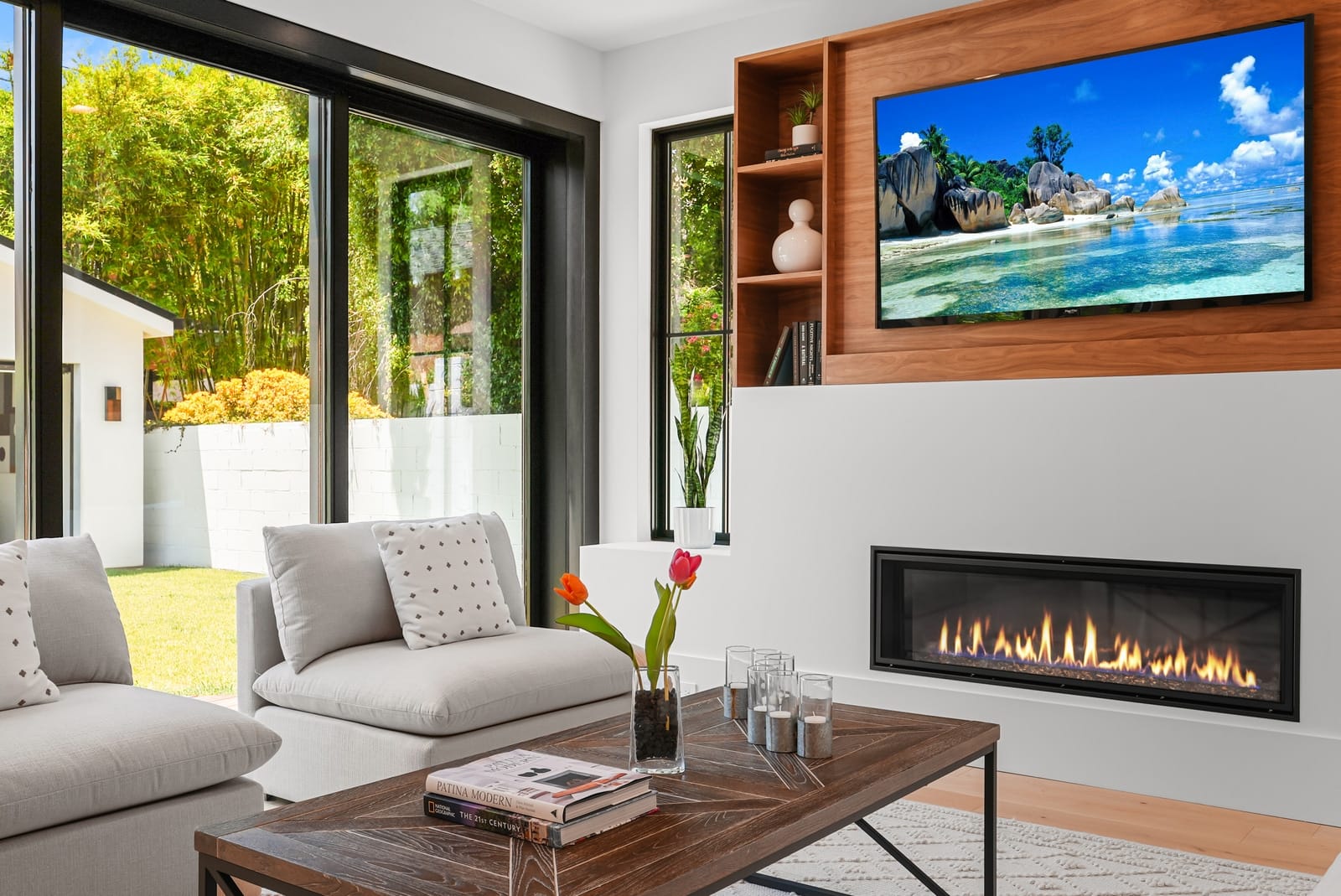 Living room with a linear fireplace under a walnut media wall