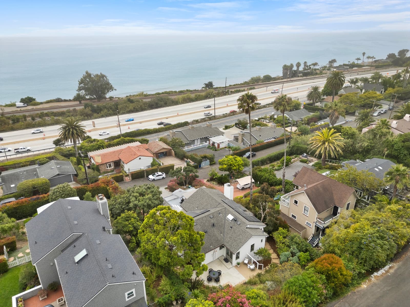 Drone over the Summerland rooftops toward the ocean