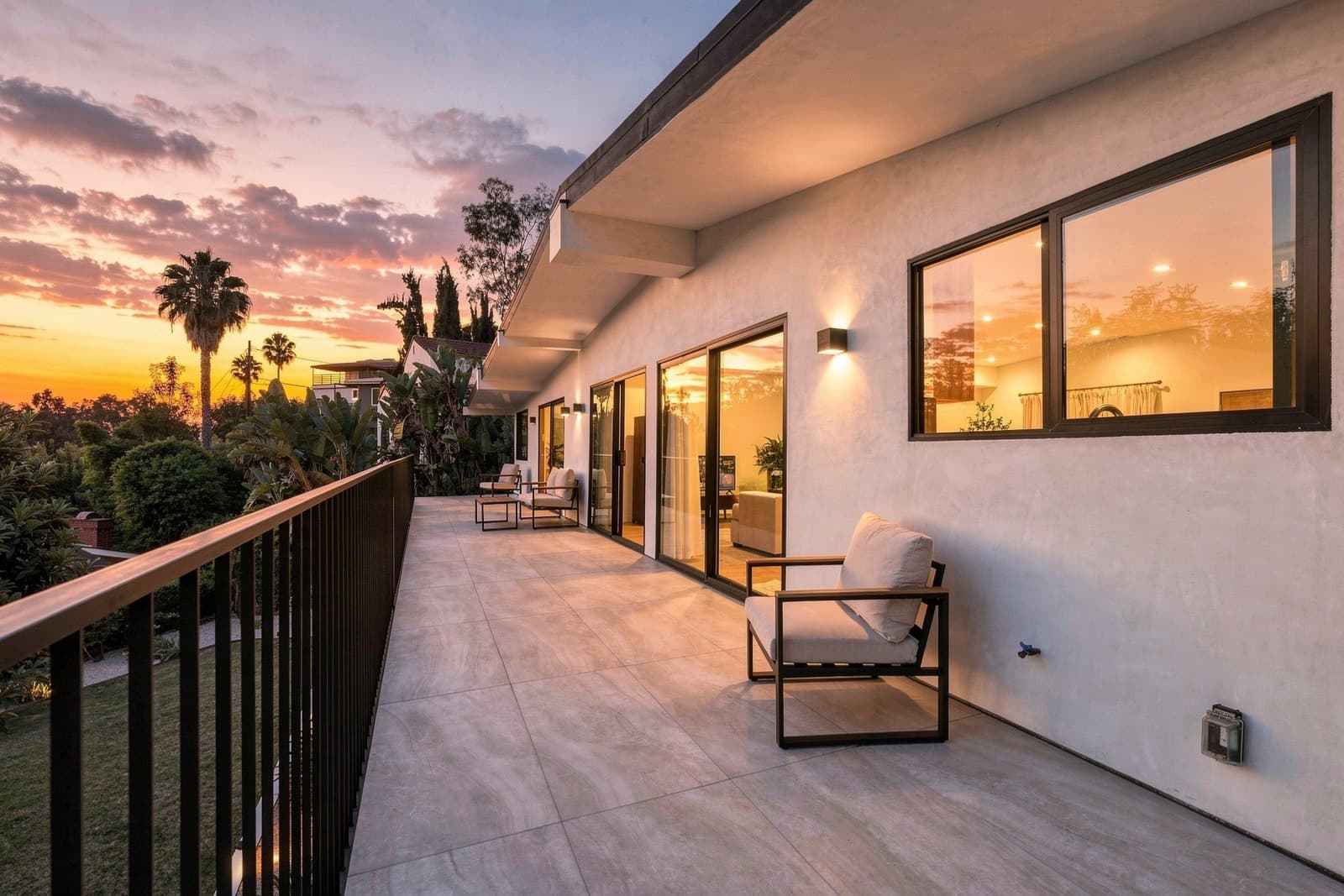 Terrace with lounge seating and a hillside view at sunset