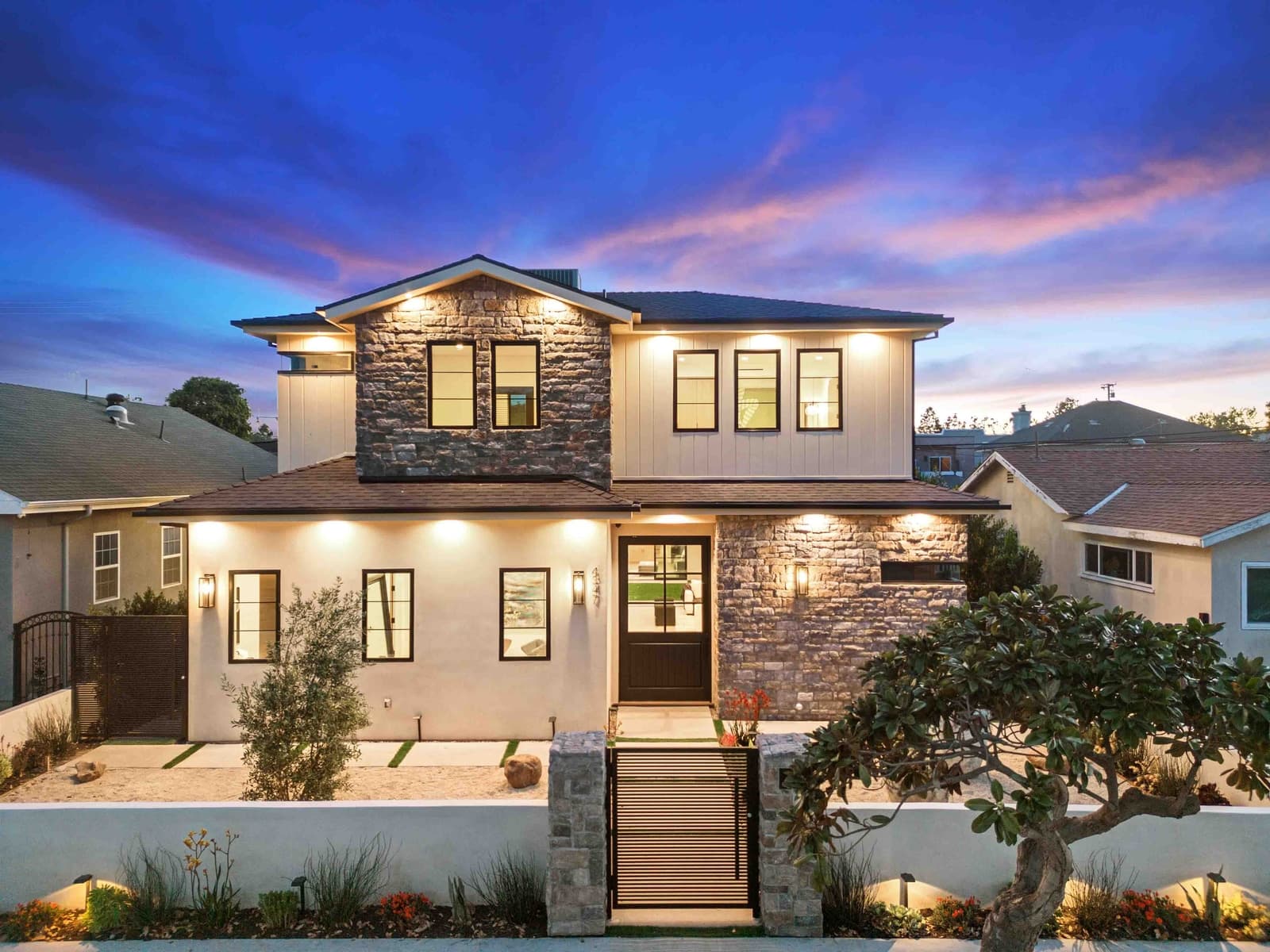 Twilight exterior showing architectural massing and warm interior glow