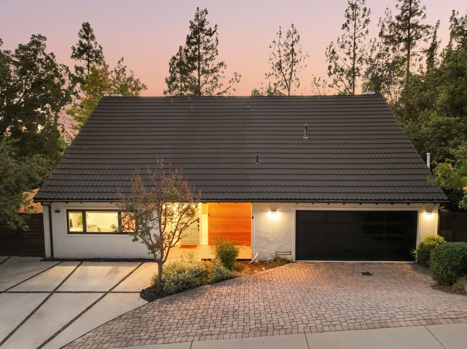 Single-story home at twilight under a pink sky