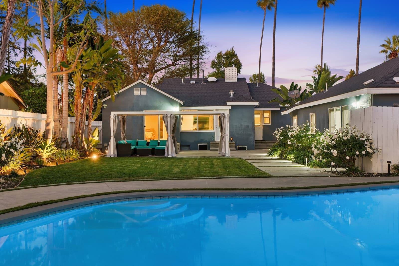 Pool at twilight with palms, the house lit behind, Van Nuys