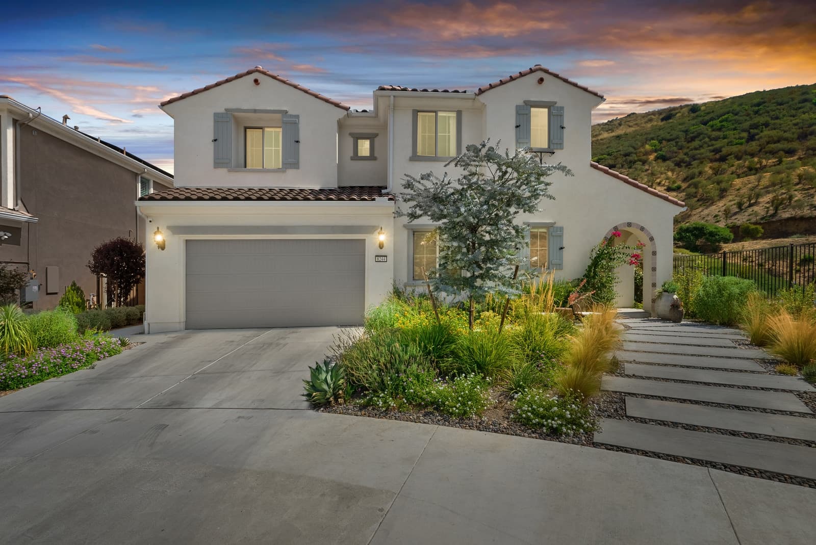 The same home at virtual twilight, sky and windows lit in the edit and labeled as virtual