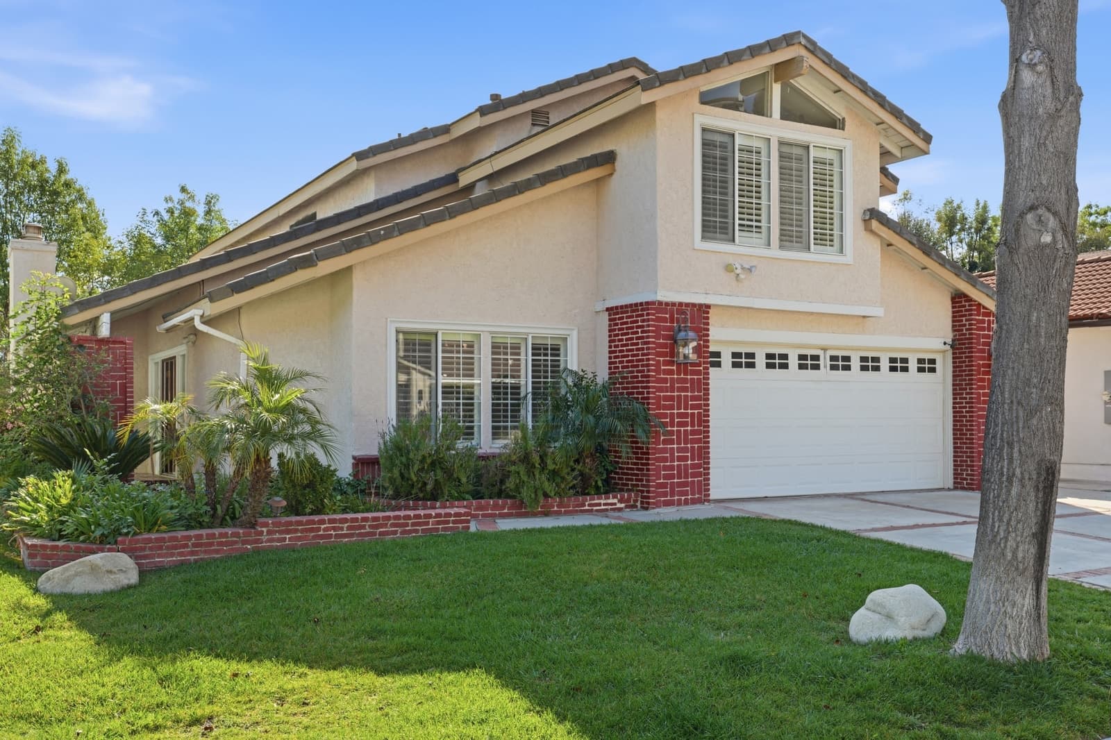 Two-story suburban home with a manicured lawn, photographed by VVT in West Hills