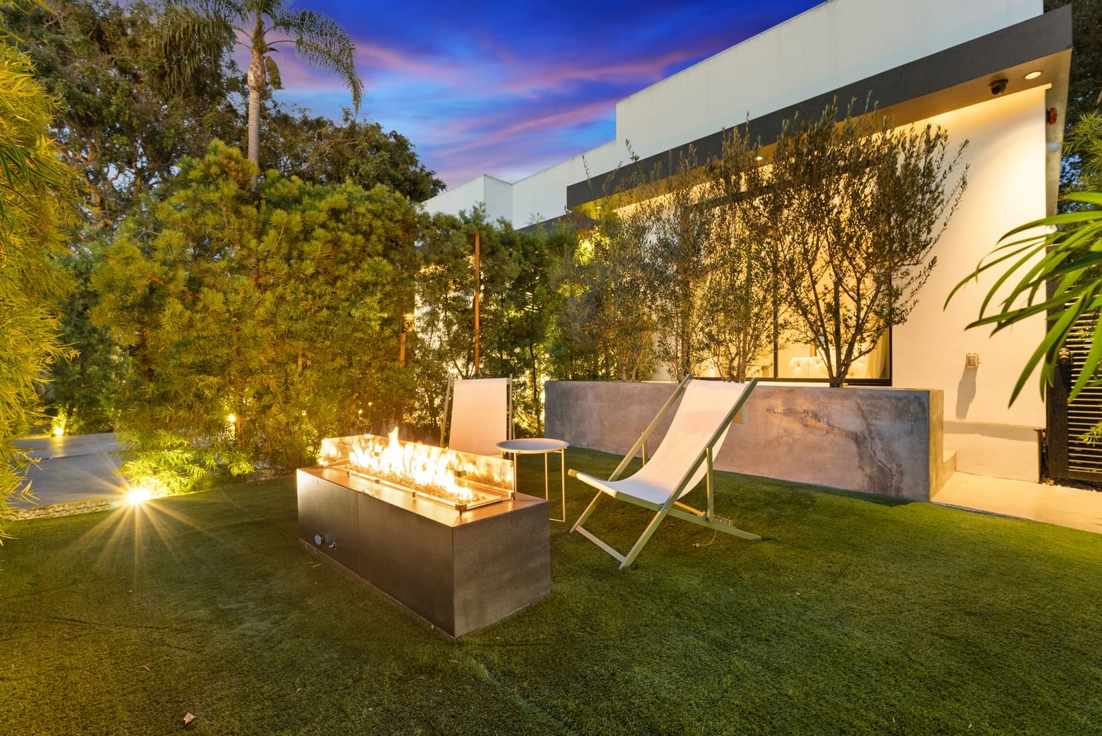 Lawn fire table at twilight beside the house
