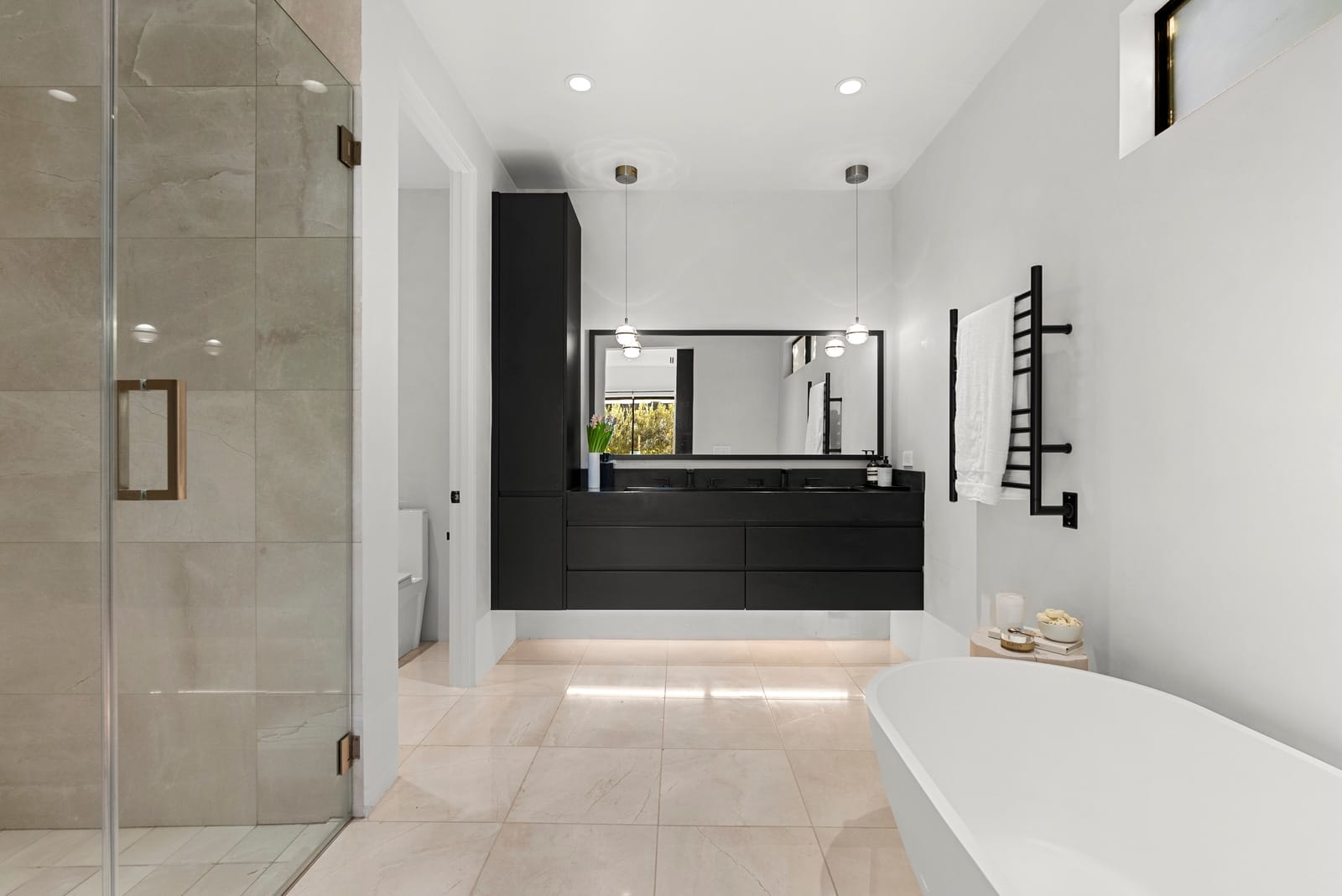 Primary bath with a freestanding tub and a black vanity