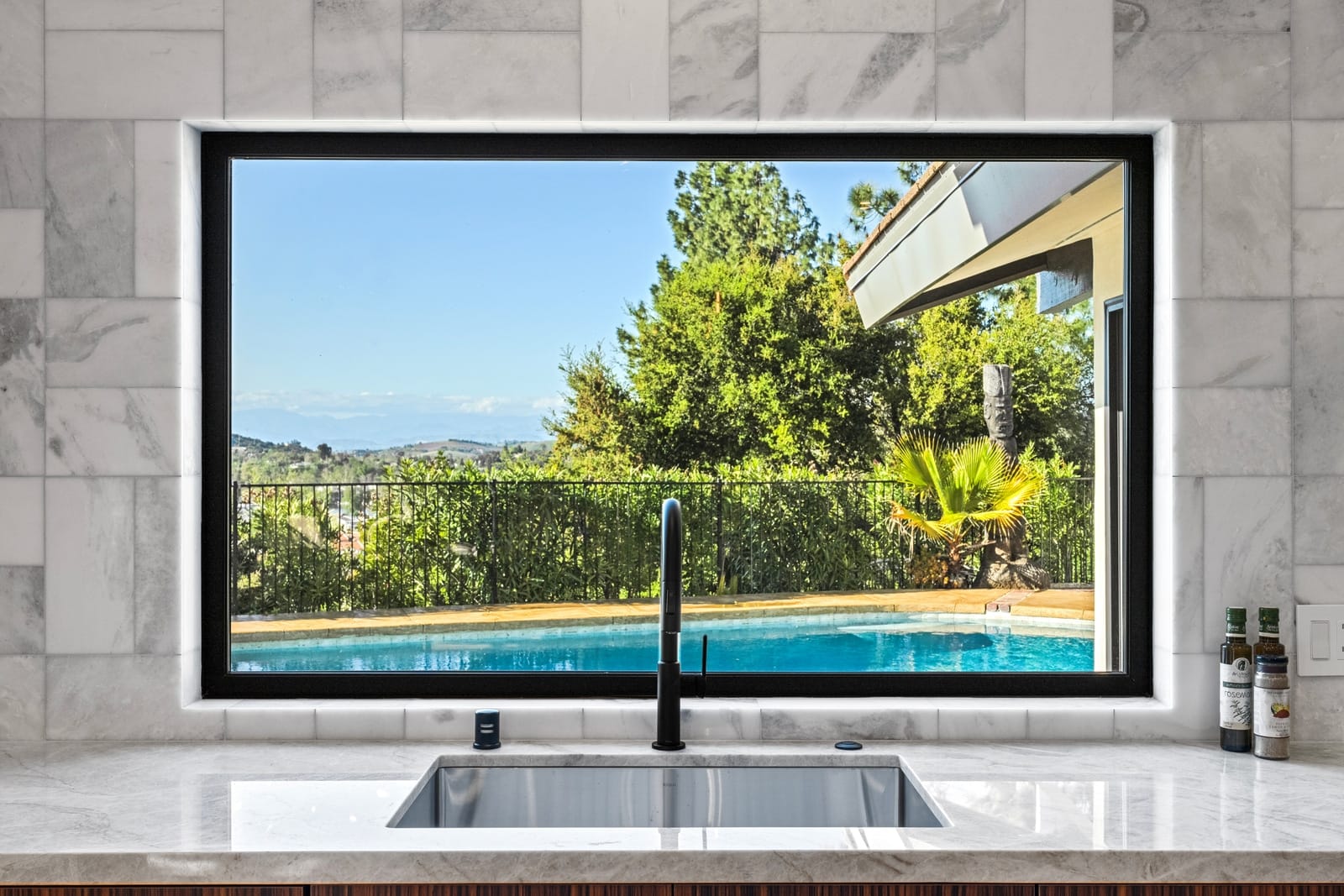 Kitchen sink under a picture window onto the pool