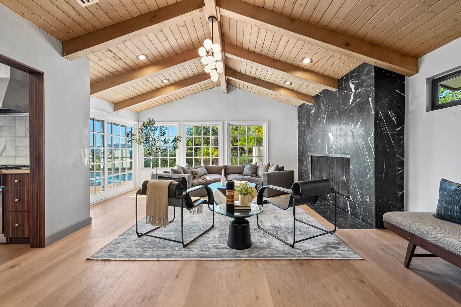 Vaulted living room with a black stone fireplace and beams