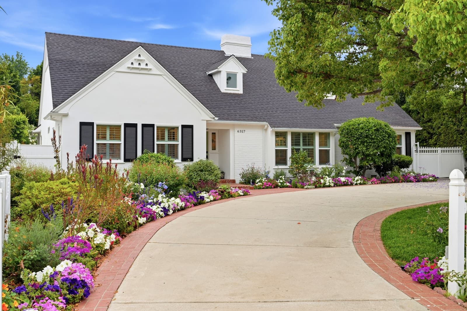 White cottage with a garden, the hero frame of a listing website