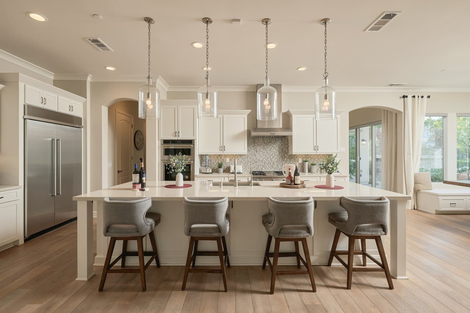 White kitchen with glass pendant lights over the island