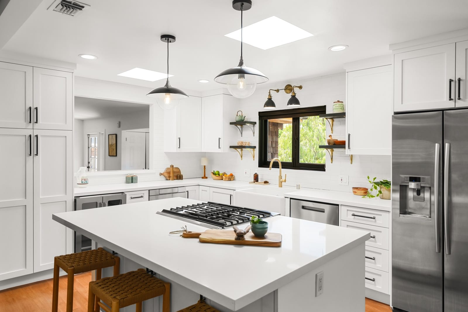 White kitchen with an island and a black-framed window