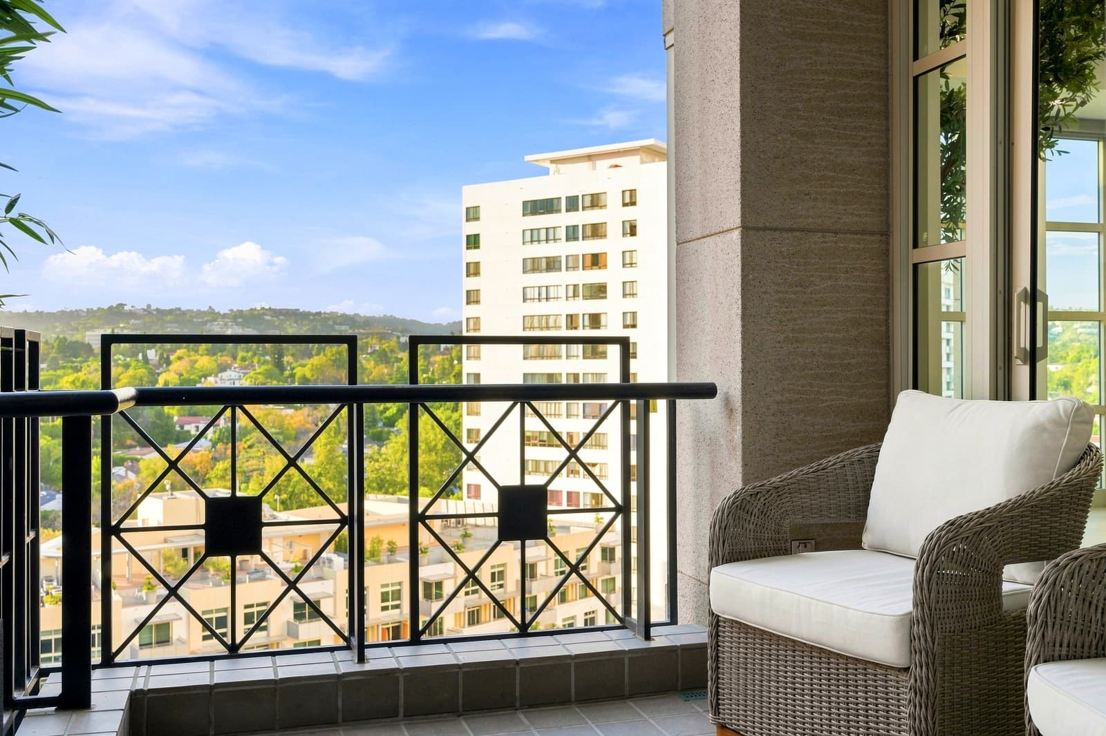 Balcony with a rattan chair looking over Westwood toward the hills