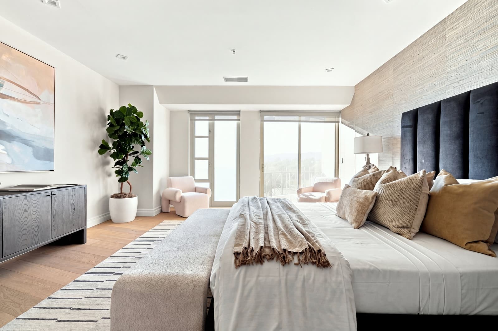 Primary bedroom with grasscloth walls and a balcony view