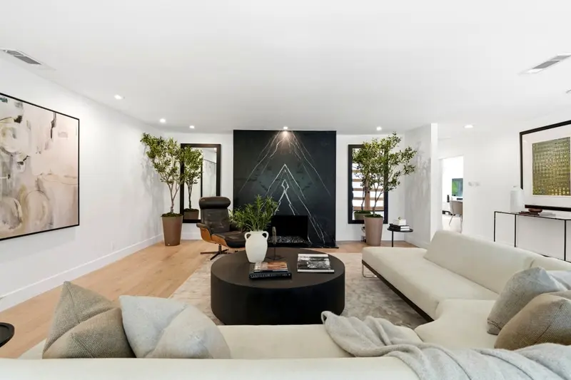 Living room with a black stone fireplace wall, oak floors and a cream sectional, Woodland Hills
